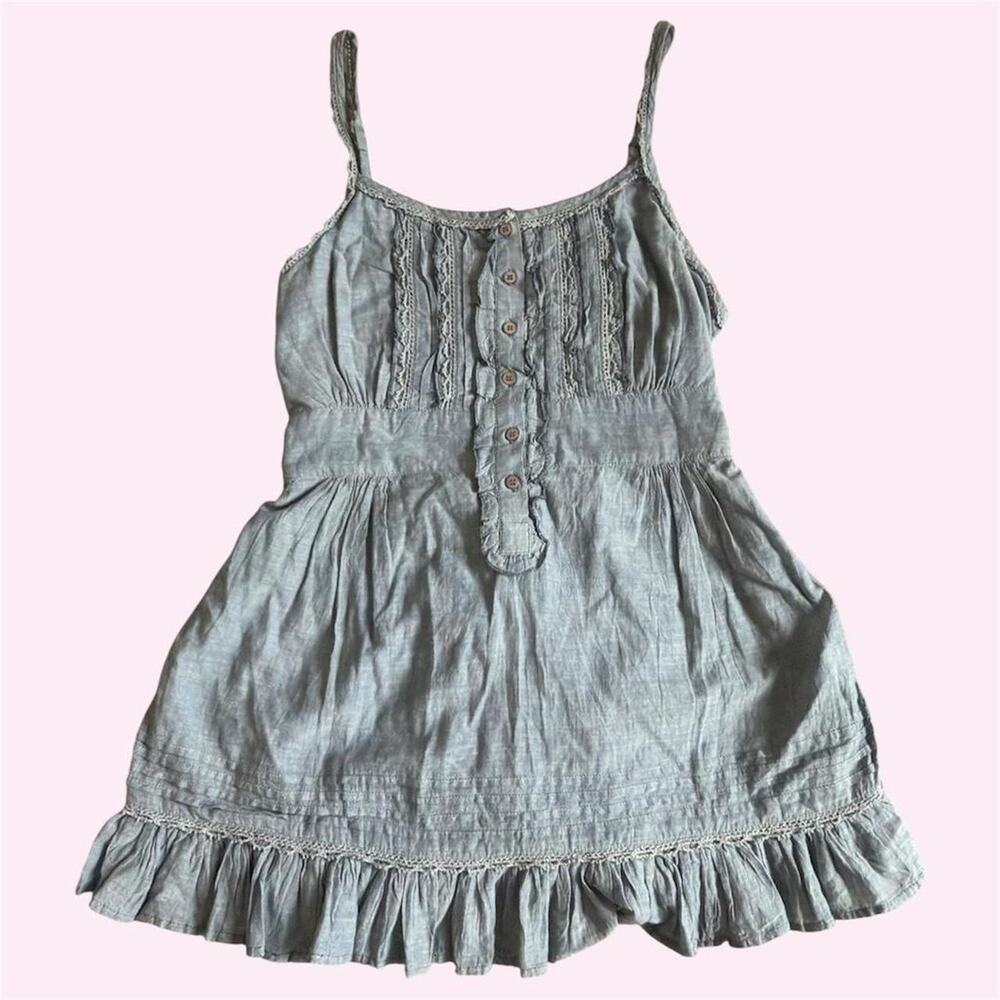 Blue denim colored babydoll top with ruffles and tie back